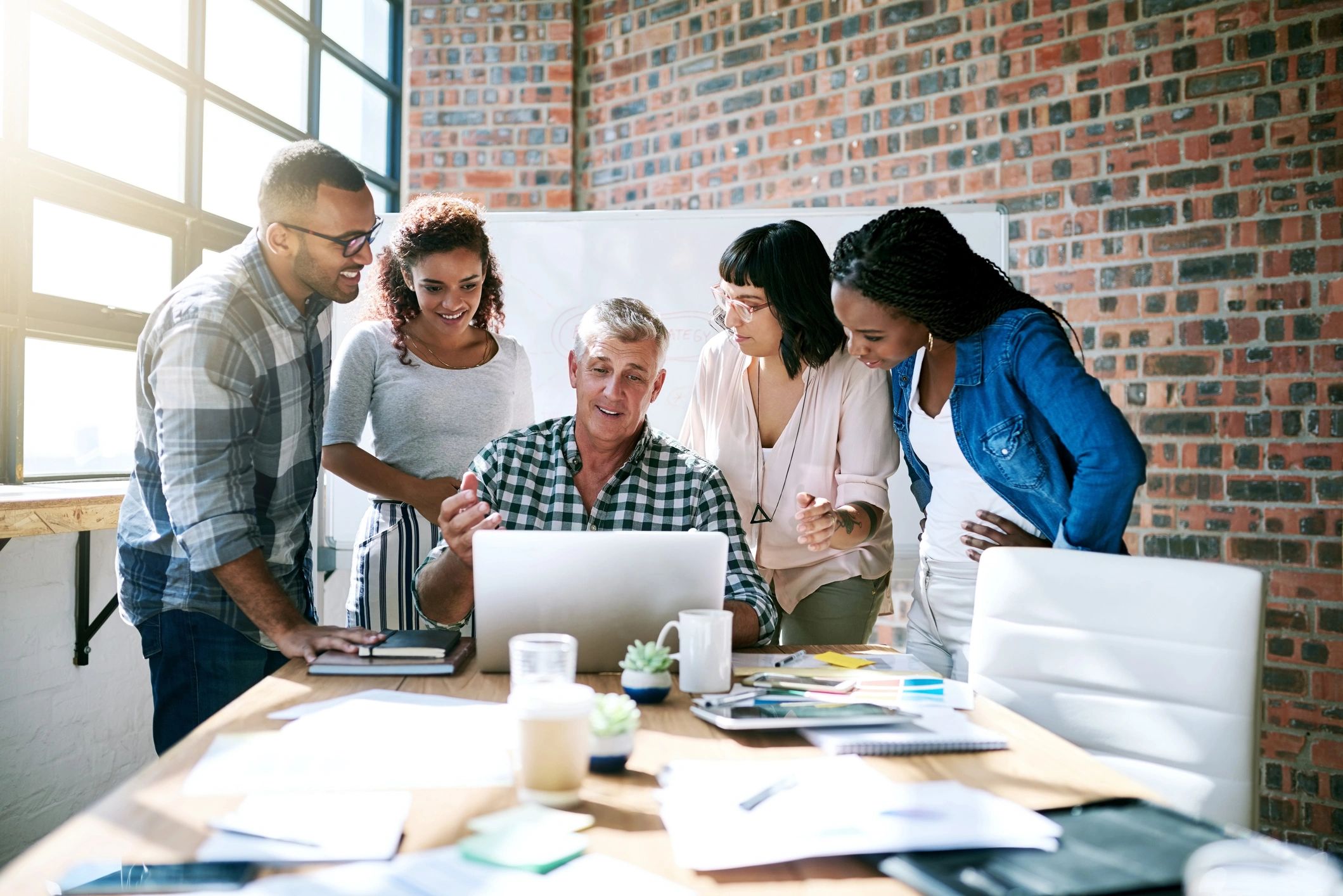 Team collaborating on a laptop in a modern office
